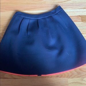 Short pleated navy blue skirt W/orange lining.